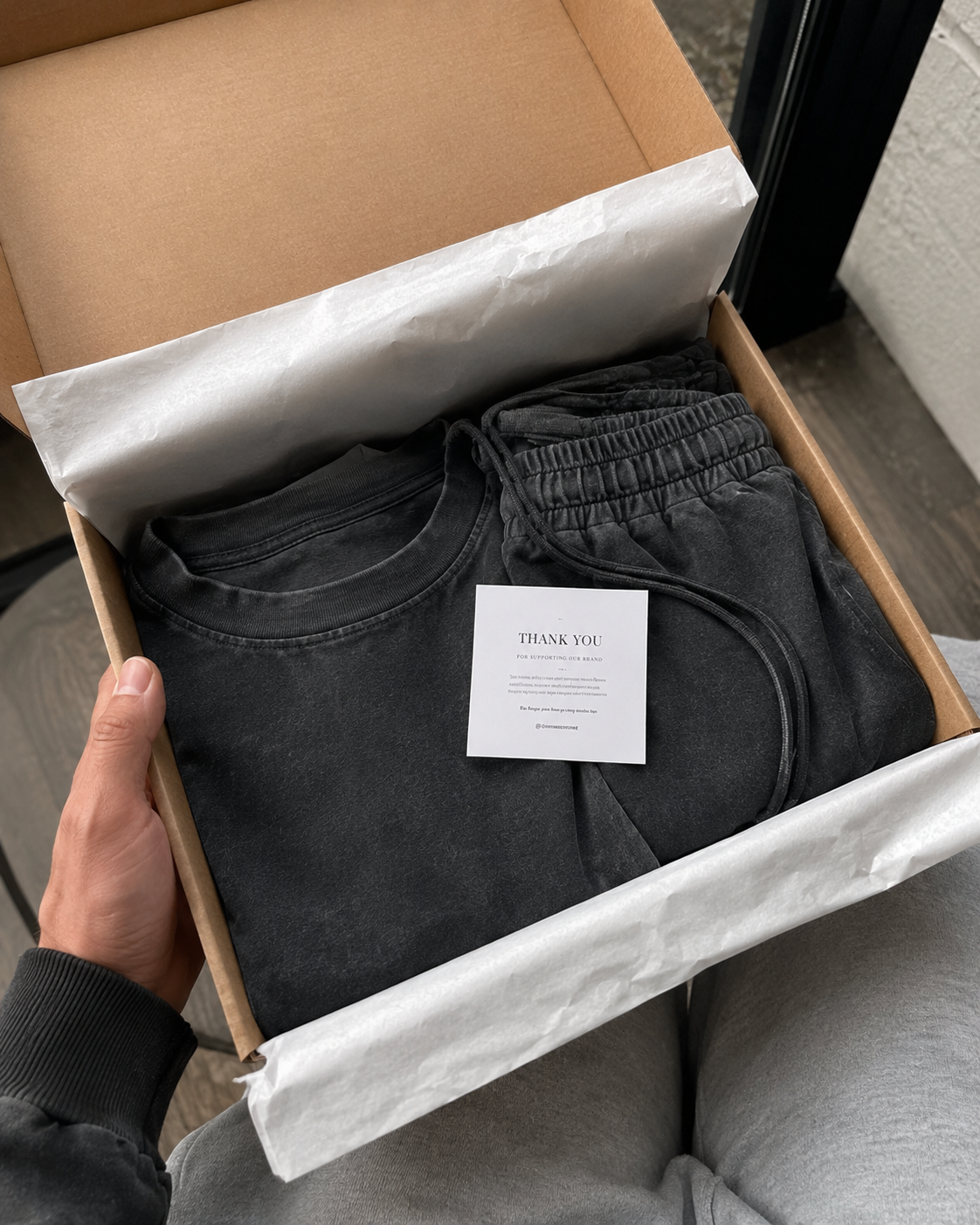 Conjunto negro empaquetado en caja kraft con acabado premium.